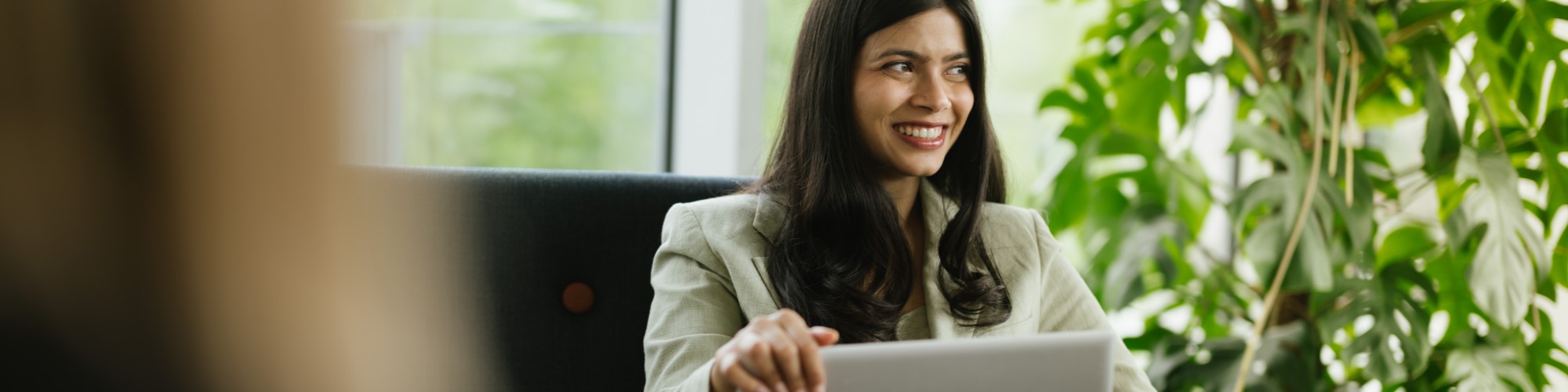 A young woman looks happy as she shops online on her laptop